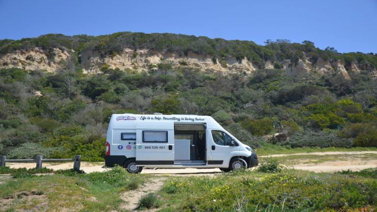 foto exterior autocaravana na praia. Fonte da Telha, Almada, Setúbal, Lisboa em Portugal. we rent dream vans 969326491 @werentdreamvans campervan estacionada junto mar e da praia com a escarpas ao fundo de porta aberta . aluguer de autocaravanas. aluguer autocaravanas lisboa